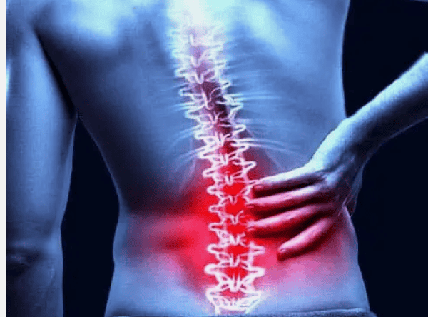 A person holding their lower back with an illustration highlighting the spine and a red glow indicating lower back pain. A person holding their lower back with an illustration highlighting the spine and a red glow indicating lower back pain.